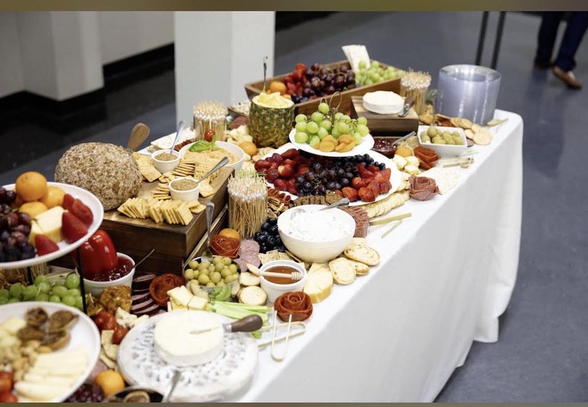 Large grazing table with fruit, cheese, crackers, and charcuterie
