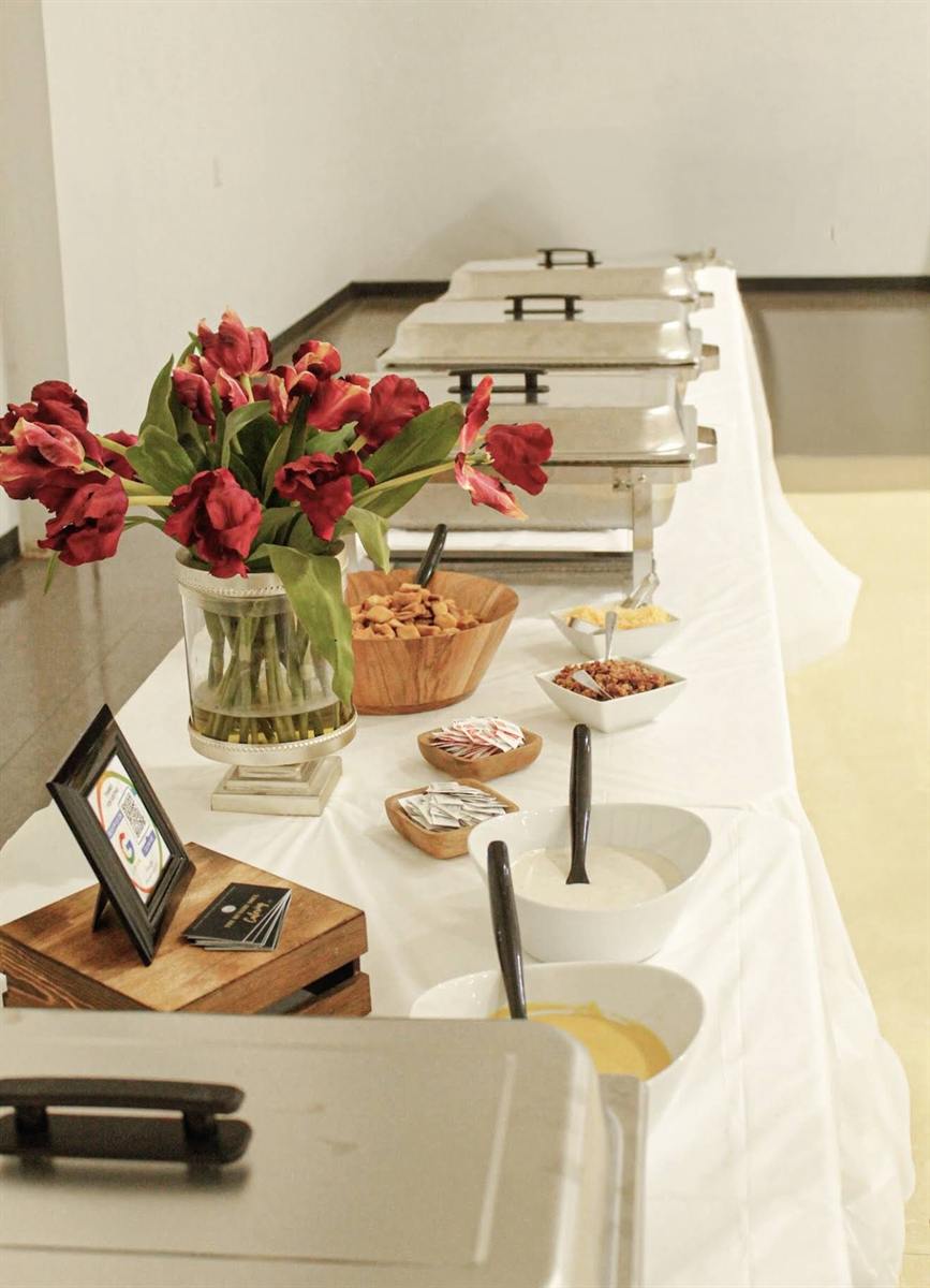 Buffet line and event setup with flowers and serving dishes