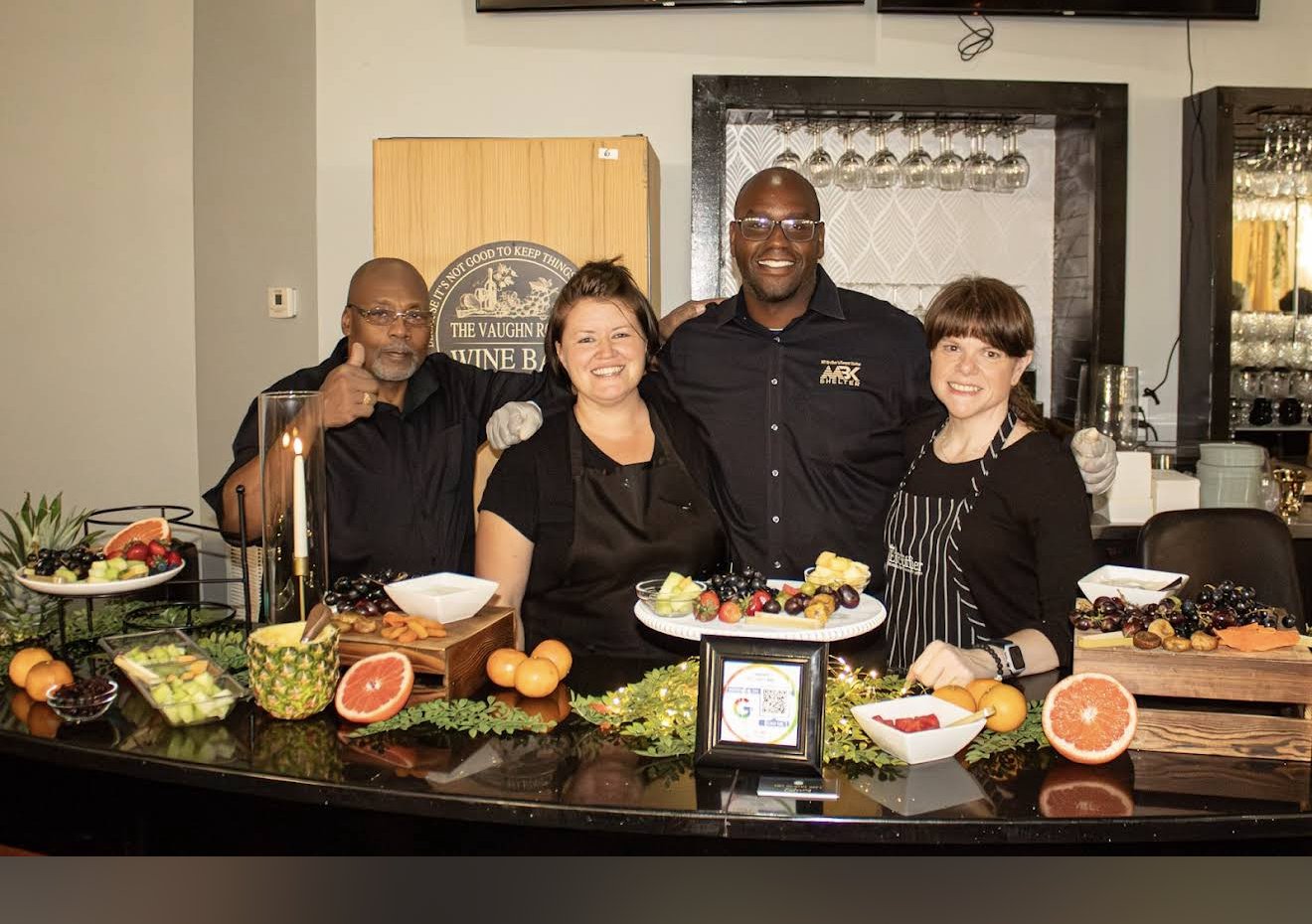 The Hungry Soul Catering team standing behind a catered food display